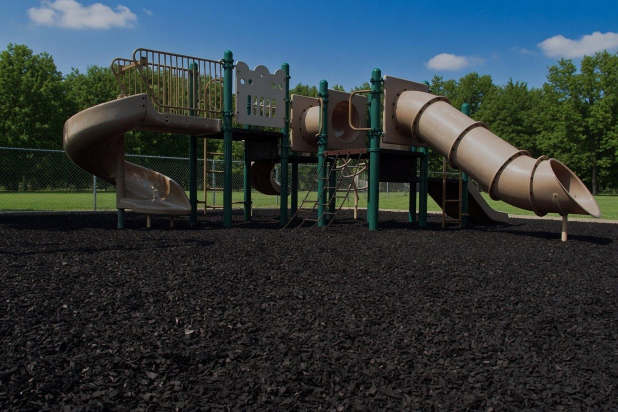 Black rubber mulch under a school playground