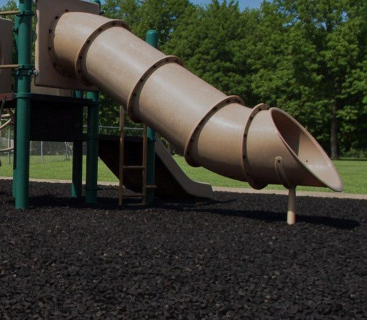 Tube slide landing on black rubber mulch