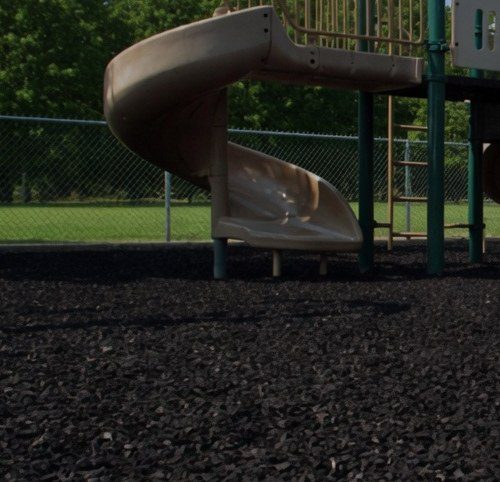 Spiral slide over black rubber mulch