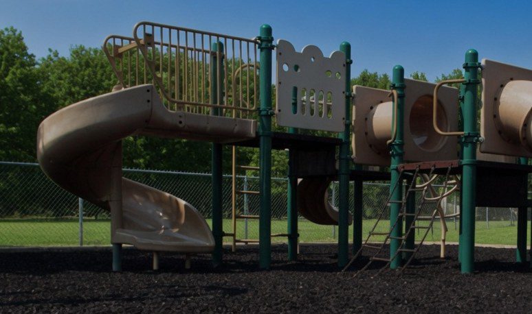 School play structure on a bed of black rubber mulch