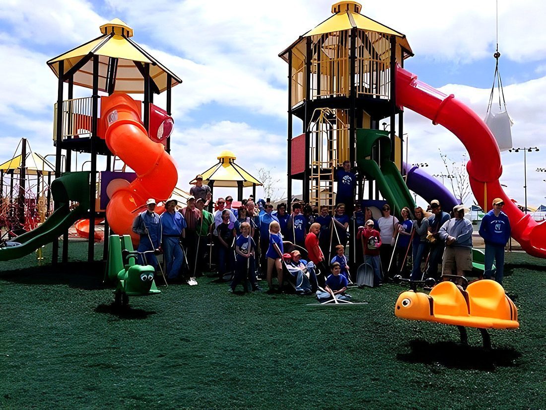 Children at a city park playground on green rubber mulch