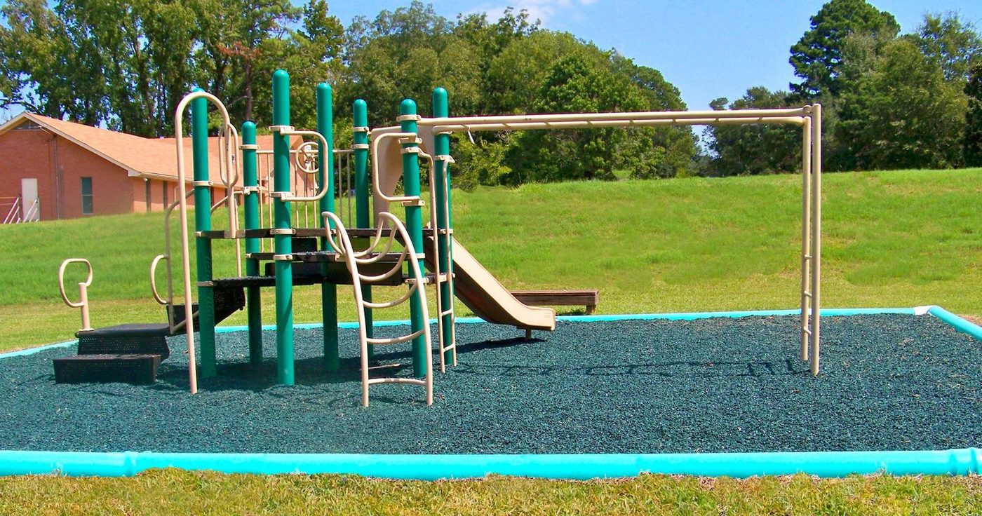 Municipal park playground on green rubber mulch
