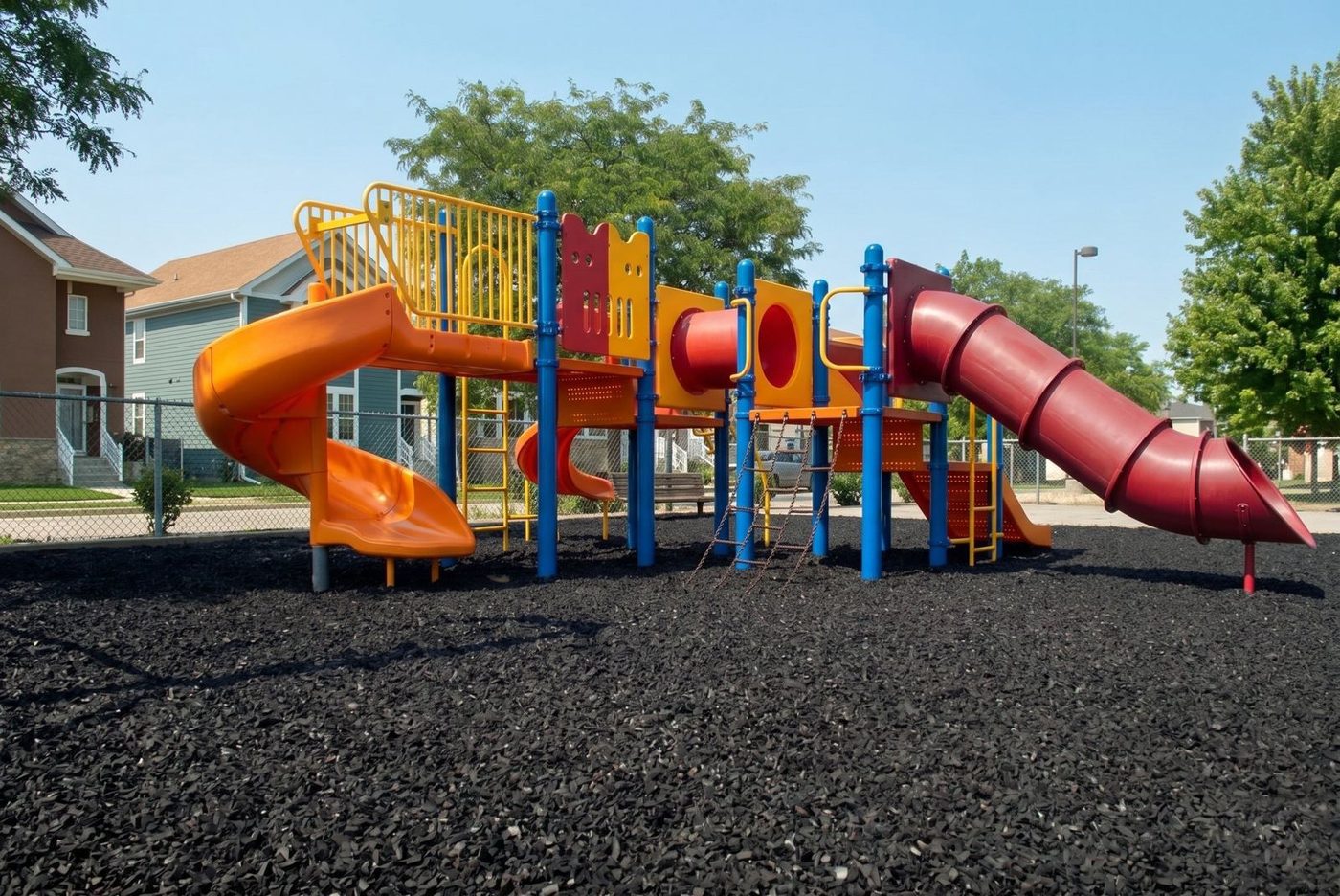Play structure with tube slides on a rubber mulch surface