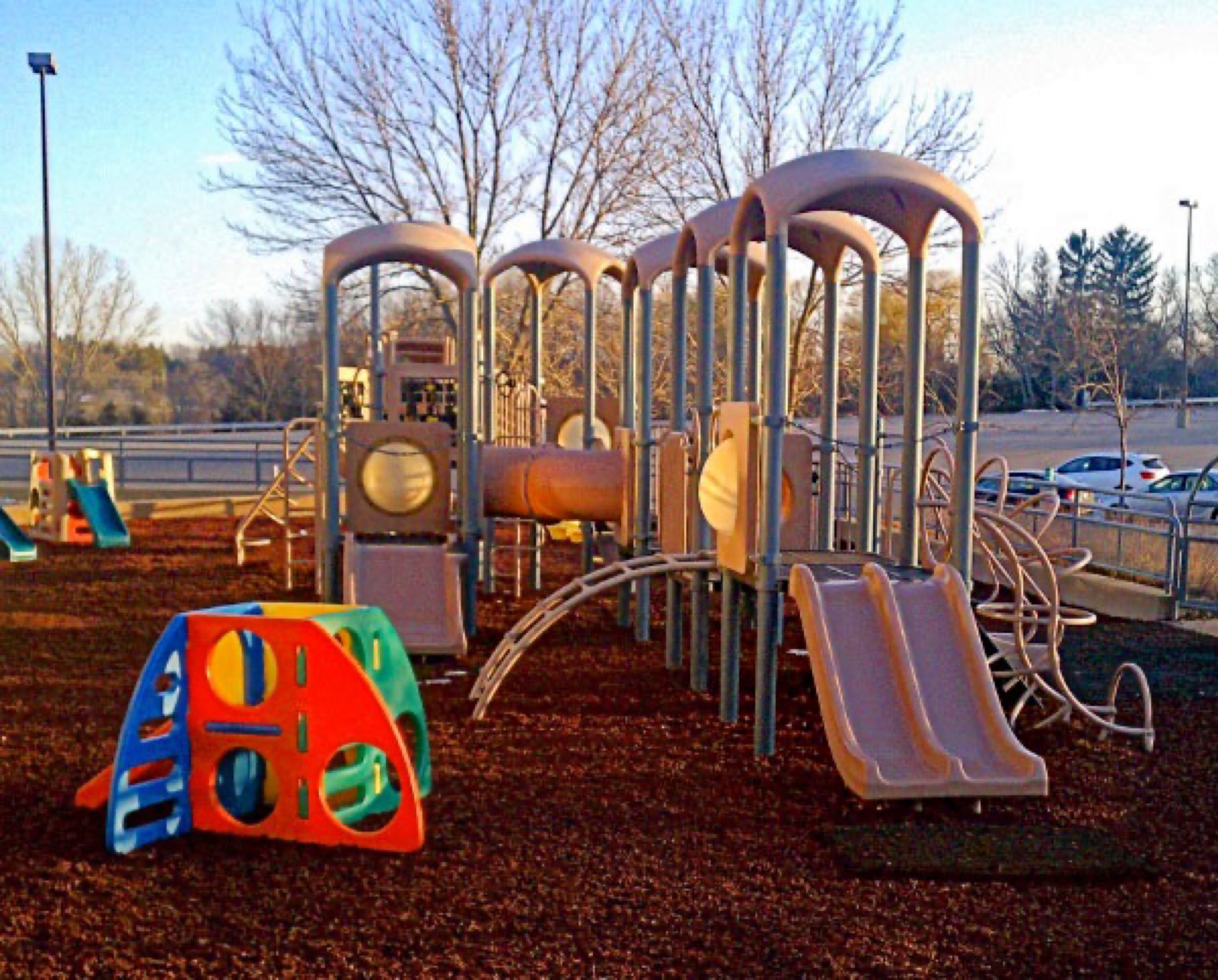 Multi-level play structure with slides on a rubber mulch safety surface