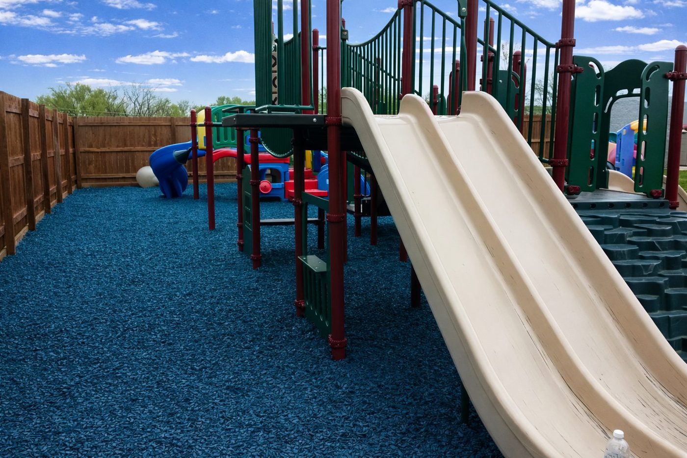 Wide slide landing on a rubber mulch play surface