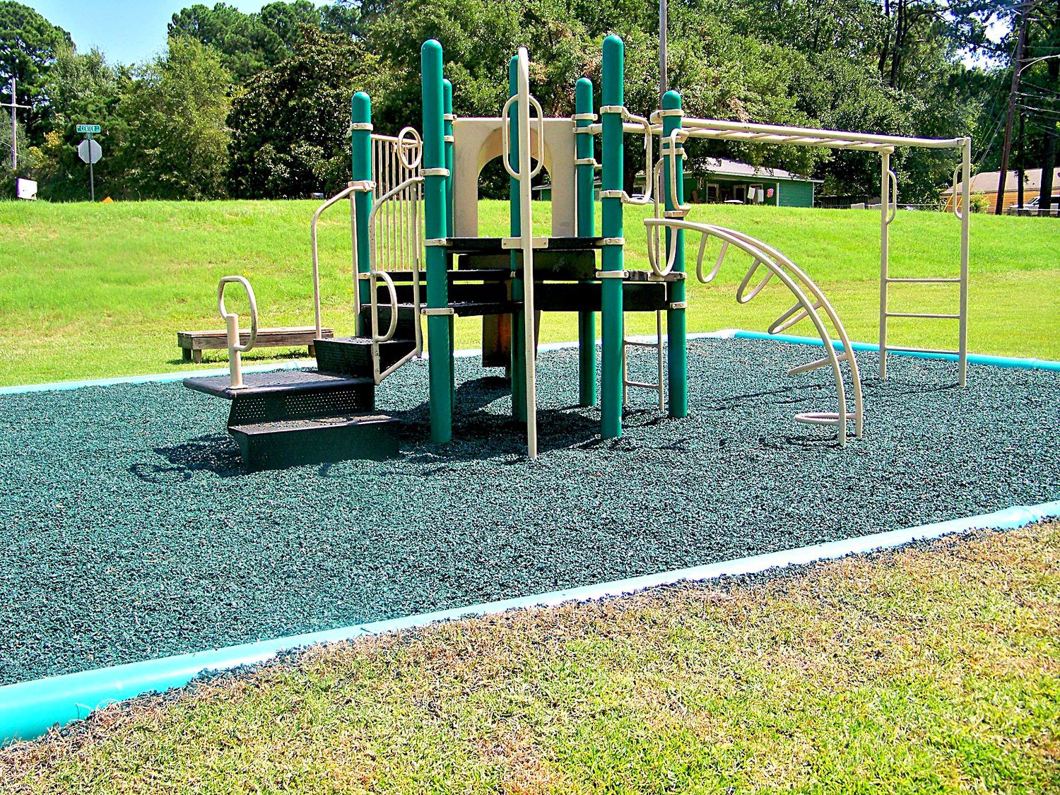 Park play structure with climbers on a rubber mulch surface