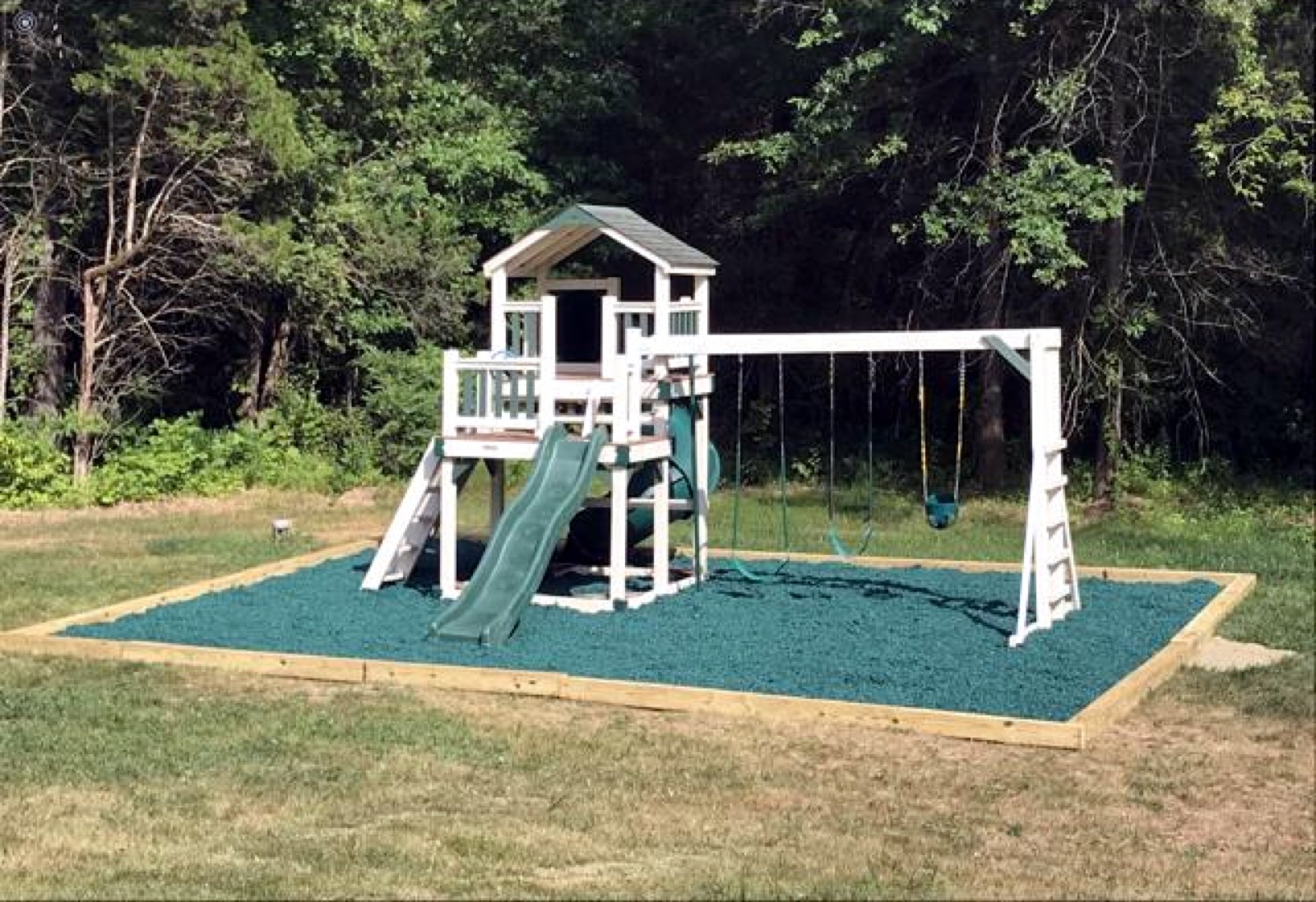 Swing set and playhouse on a rubber mulch pad