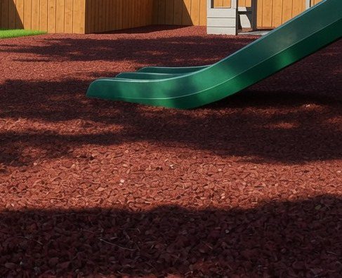 Green slide over redwood rubber mulch