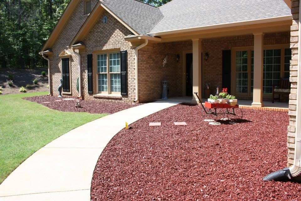 Red, redwood-toned rubber mulch in a home landscape bed