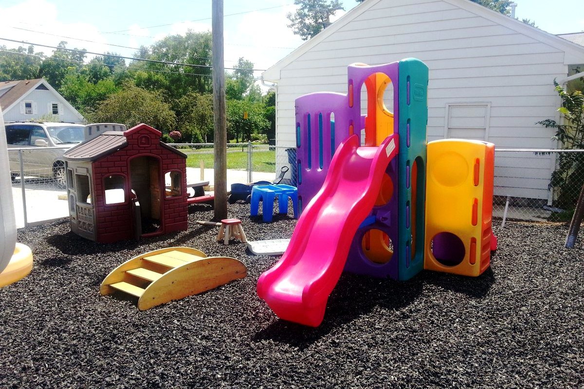 Play structures and a playhouse on a rubber mulch surface