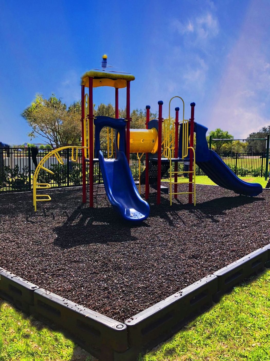 Commercial play structure with a slide on rubber mulch