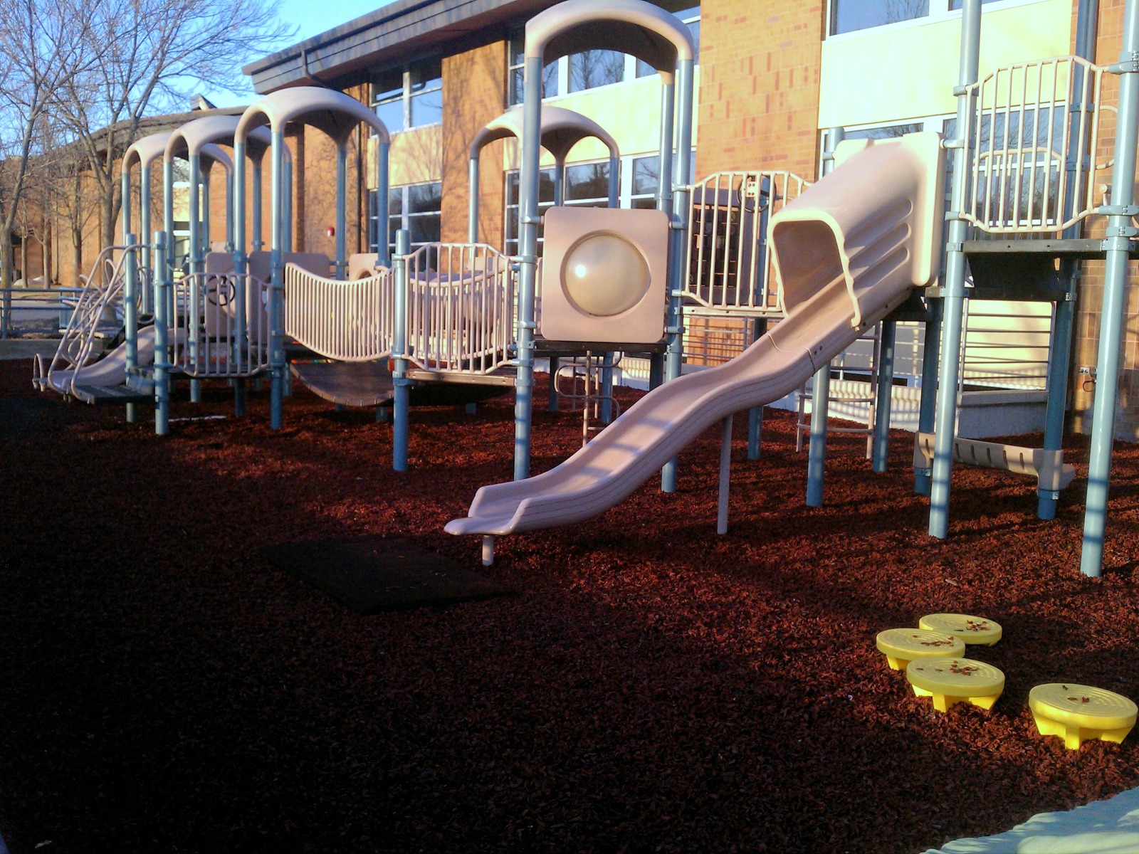 Covered play structure over a rubber mulch safety surface